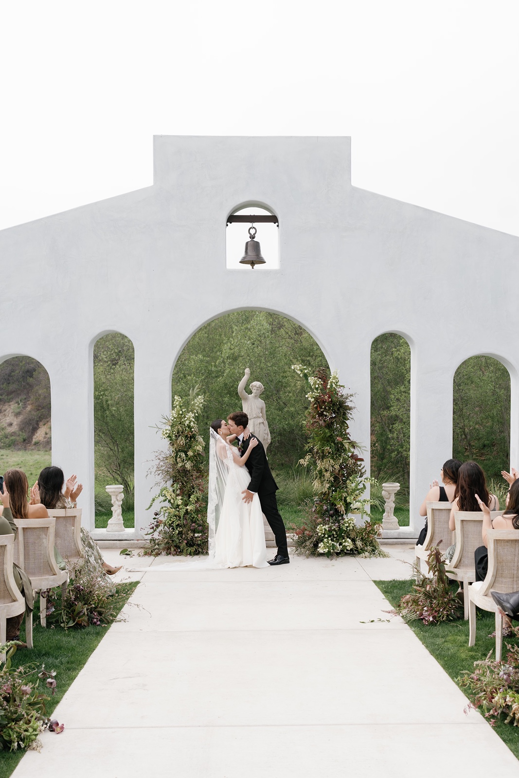 Bride and groom kiss at their Jeune Perche Estate wedding ceremony