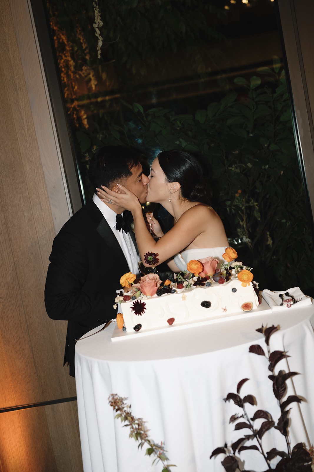 Couple kisses after cutting the cake at their Estate Yountville wedding