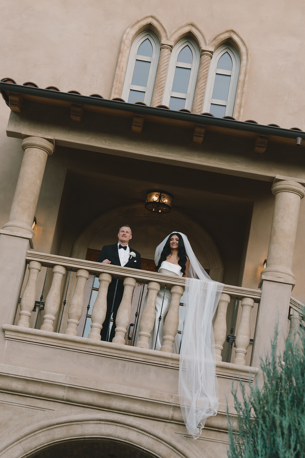 Bride and groom stand on the balcony at their Allegretto Vineyard wedding