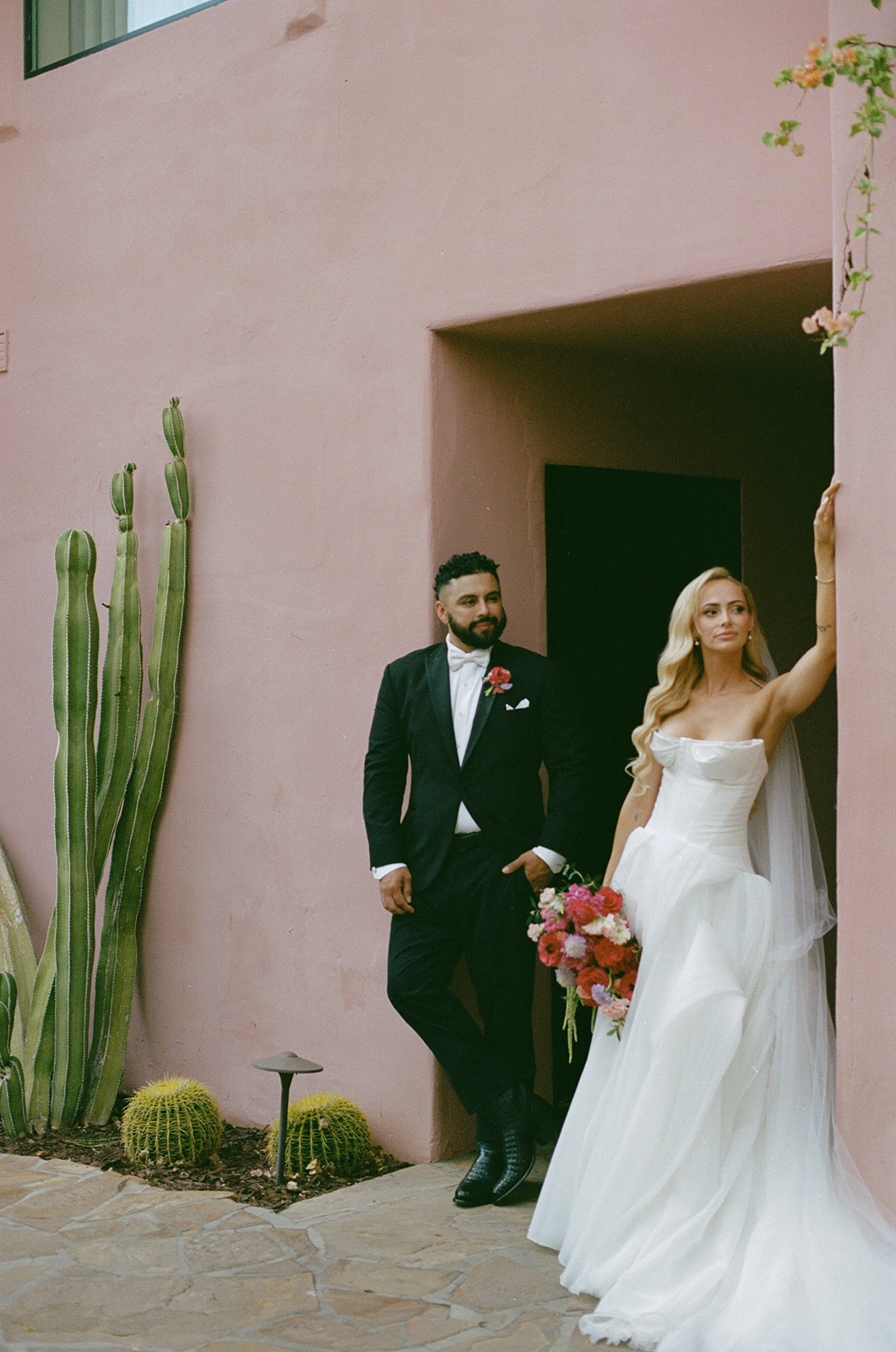 Bride and groom in front of pink building at their Sands Hotel & Spa wedding