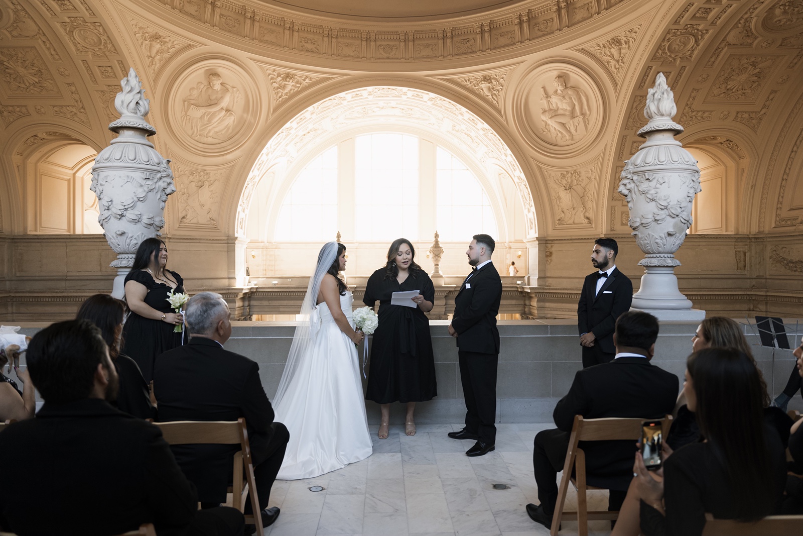Bride and groom say vows as guests look on at San Francisco City Hall