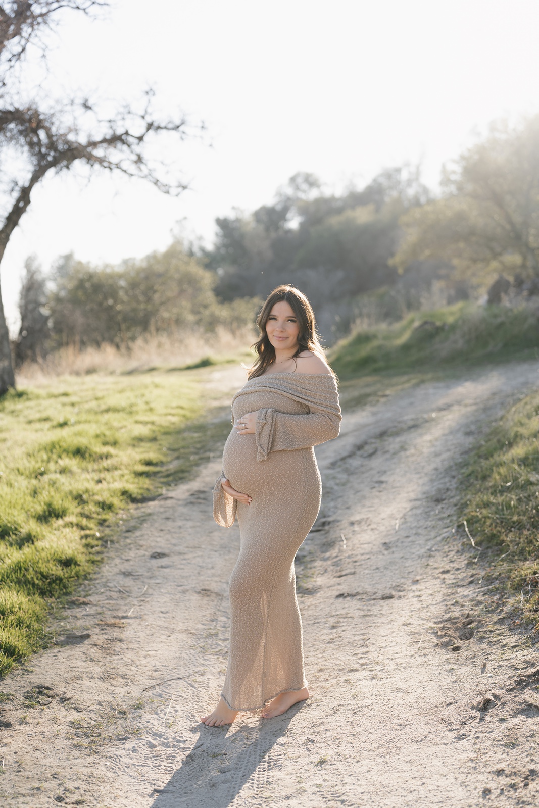 Woman poses in brown strapless dress at maternity photos in Sacramento