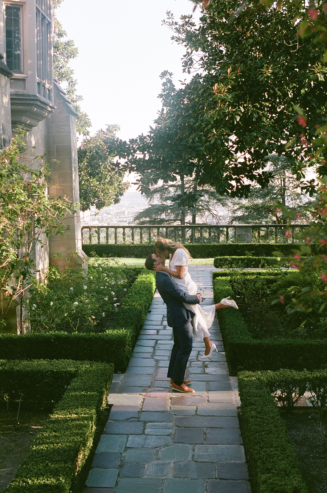 Man picks up woman during Los Angeles engagement photos outdoors